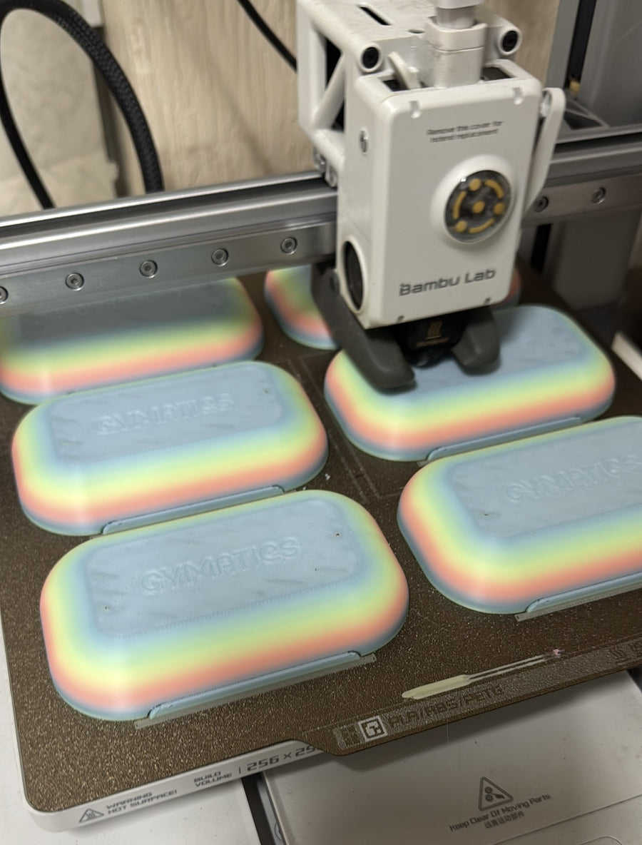 A Bambu Lab A1 printing rainbow Gymatics lids